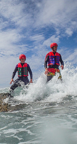 Father and son standing on rock and waves lap at their feet