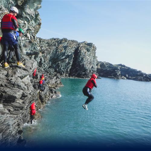 Womain performs Coasteering jump with arms folded